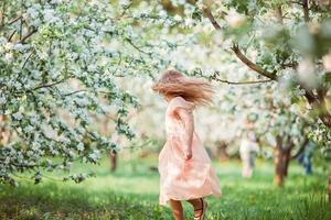 jolie fille dans un jardin de pommiers en fleurs profitez de la chaude journée photo