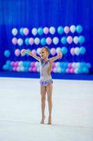 belle petite fille gymnaste active avec sa performance sur le tapis photo