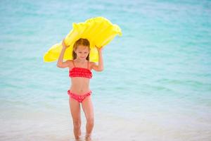 adorable petite fille pendant les vacances à la plage s'amusant en eau peu profonde photo