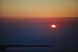célèbre coucher de soleil au-dessus de la caldeira vue sur la mer dans l'île de santorin photo