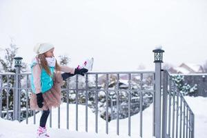 adorable petite fille patinant sur la patinoire à l'extérieur en hiver journée de neige photo
