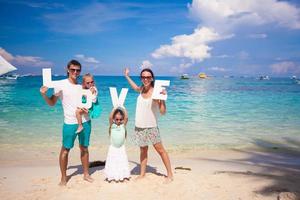 jeune famille et deux enfants avec mot amour en vacances tropicales photo