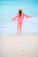 empreintes de pas humaines sur la plage de sable blanc avec un beau fond de jeune femme. femme sur la plage photo