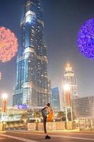 fille heureuse marchant à dubaï avec un gratte-ciel en arrière-plan. photo