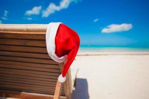 Chapeau de Père Noël sur une chaise longue à la plage tropicale des Caraïbes photo