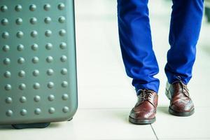 gros plan sur les chaussures et les bagages pour hommes à l'aéroport. jeune touriste à l'aéroport prêt à voyager