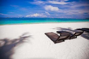chaises de plage sur la belle île de plage de sable blanc photo