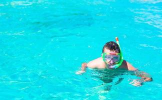 jeune homme plongée en apnée dans des eaux turquoises tropicales claires photo