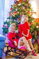 petites filles déguisées en père noël près de l'arbre de noël photo