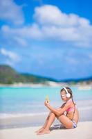 petite fille écoutant de la musique au casque sur la plage. adorable enfant profiter de la musique au bord de la mer photo