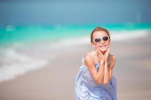 petite mignonne souriante sur la plage pendant les vacances d'été photo