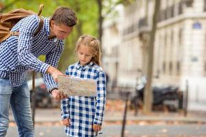 adorable petite fille et père avec carte de la ville européenne à l'extérieur photo