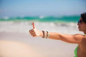 Thumbs up sign on a woman's hand background la mer turquoise photo