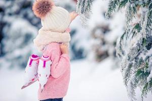 mignonne petite fille va patiner à l'extérieur. photo