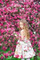 petite fille dans un jardin de pommiers en fleurs profiter du printemps photo