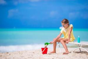 adorable petite fille jouant avec des jouets en vacances à la plage. un enfant joue avec du sable photo