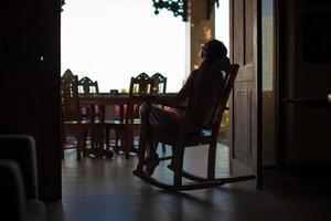 jeune femme dans un fauteuil à bascule sur la terrasse photo