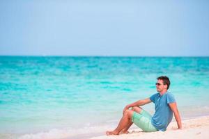 jeune homme appréciant la musique sur la plage blanche photo