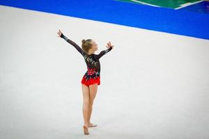 belle petite fille gymnaste active avec sa performance sur le tapis photo