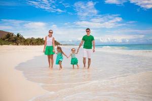 belle jeune famille de quatre personnes aimait se détendre sur la plage photo