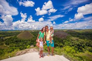 jeune famille avec deux filles sur fond de collines de chocolat à bohol photo