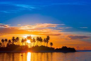 beau coucher de soleil coloré sur une île tropicale aux maldives dans l'océan indien photo