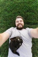 homme avec petit chaton couché et jouant sur l'herbe - amitié amour animaux et concept de propriétaire d'animal photo