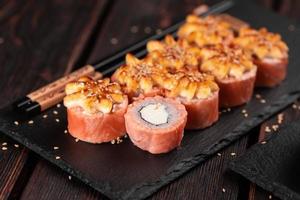 sushi roll philadelphia avec saumon et fromage à la crème sur fond noir gros plan. menu de sushis. concept de cuisine japonaise