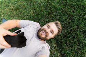 homme avec petit chaton couché et jouant sur l'herbe - amitié amour animaux et concept de propriétaire d'animal photo