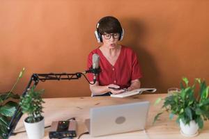 présentatrice de radio d'âge moyen parlant dans le microphone et lisant les nouvelles - concept de diffusion de radio en ligne photo