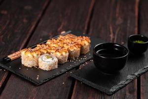 sushi roll philadelphia avec poulet avocat et fromage à la crème sur fond noir gros plan. menu de sushis. concept de cuisine japonaise photo