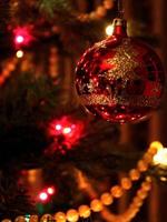 Ornement de boule de Noël rouge réfléchissant sur l'arbre