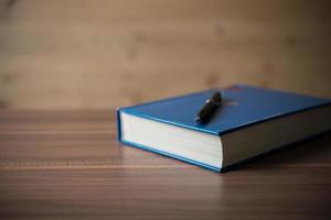 livre avec un stylo sur une table en bois photo