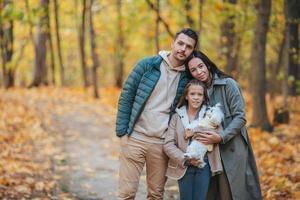 portrait d'une famille heureuse de trois personnes le jour de l'automne photo