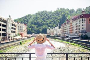 fille heureuse au chapeau sur le talus d'une rivière de montagne dans une ville européenne. photo