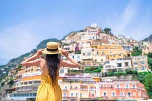 vacances d'été en italie. jeune femme dans le village de positano en arrière-plan, côte amalfitaine, italie
