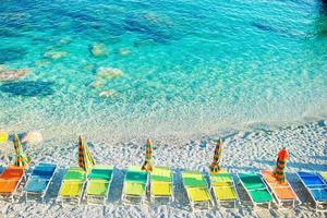 transats et parasols au beau bord de mer européen à monterosso en italie, cinque terre, ligurie photo