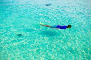 jeune garçon plongée en apnée dans l'océan tropical turquoise photo