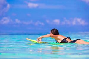 Belle surfeuse de remise en forme surfant pendant les vacances d'été photo