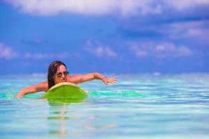 Belle surfeuse de remise en forme surfant pendant les vacances d'été photo