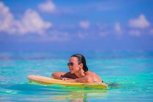 Belle surfeuse de remise en forme surfant pendant les vacances d'été photo