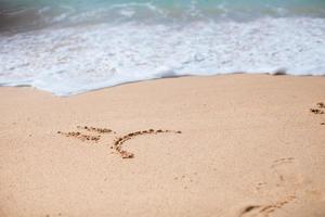 sourire triste s'appuyant sur le sable à la plage tropicale photo