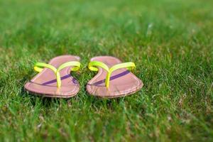 Libre de tongs lumineuses sur l'herbe verte photo