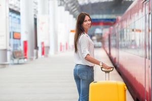 jeune femme avec des bagages sur la plate-forme du train en attente d'aeroexpress photo