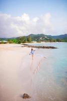 jeune femme heureuse sur la plage blanche marchant photo