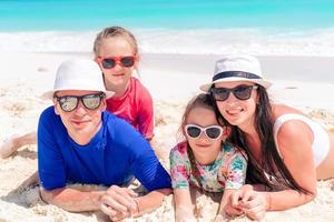 une famille heureuse avec des enfants se promène sur la plage au coucher du soleil photo