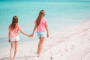 les petites filles drôles et heureuses s'amusent beaucoup sur la plage tropicale en jouant ensemble. photo