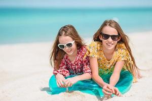 les petites filles drôles et heureuses s'amusent beaucoup sur la plage tropicale en jouant ensemble. photo