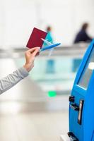 passeport en gros plan faisant l'enregistrement pour le vol ou achetant des billets d'avion à l'aéroport photo