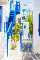 les rues étroites de l'île aux balcons bleus, escaliers et fleurs. belle architecture extérieure de bâtiment de style cycladique. photo